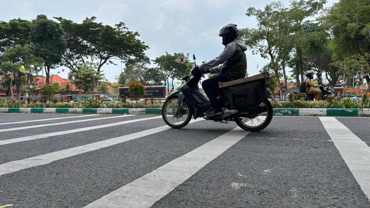 PELAN-PELAN: Kendaraan bermotor melintasi markah pita kejut di Kelurahan Bugih, Pamekasan, Senin (2/3).