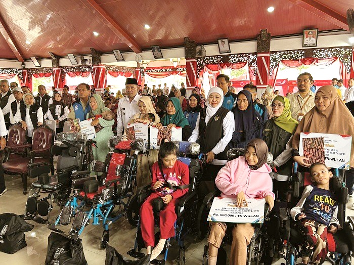 SIMBOLIS: Bupati Sampang Slamet Junaidi mendampingi Gubernur Jatim Khofifah Indar Parawansa berpose bersama penerima bansos di Pendopo Trunojoyo Selasa (3/3). (UBAIDILLAHIR RAIE/JPRM)
