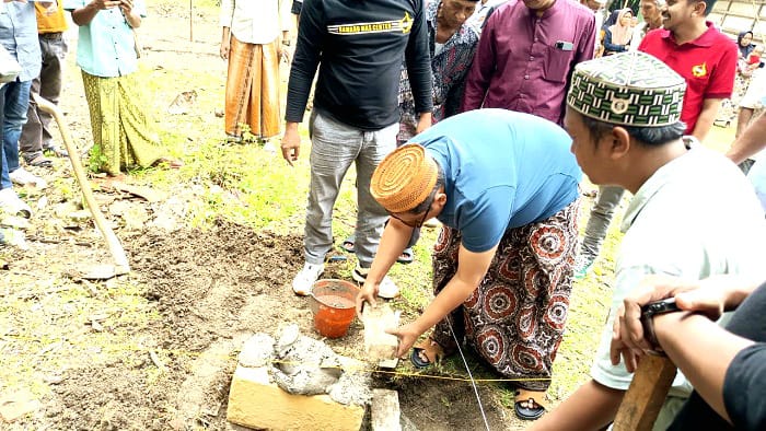 DERMAWAN: Haji Her meletakkan baru pertama dalam pembangunan RTLH di Desa Pangeleyan, Kecamatan Tanah Merah, Bangkalan, Selasa (3/3). (ZEINAL ABIDIN/JPRM)