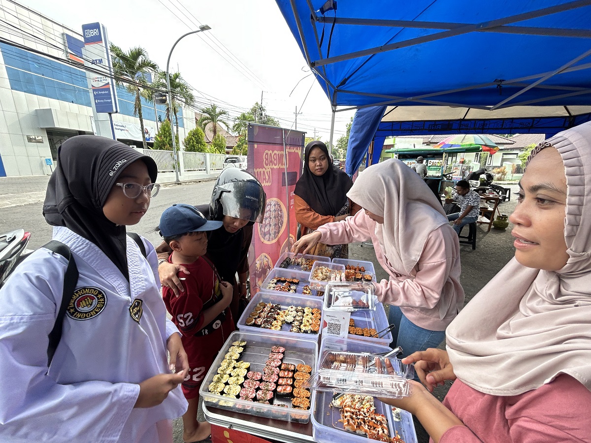 KEKINIAN: Nurul Komaria bersama rekannya melayani pembeli kimbab di stan 118 Bazar Takjil Ramadan Minggu (1/3).