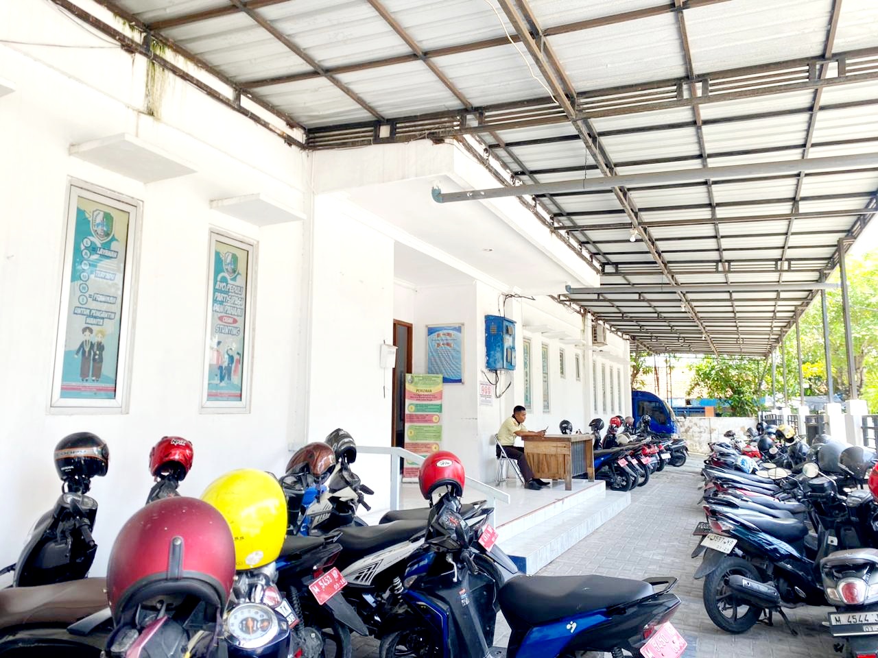 PELAYANAN: Satpam saat bertugas di kantor Dinkes KB Sampang yang terletak di Jalan KH. Wahid Hasyim Nomor 53 Sampang kemarin. (AYU LATIFAH/JPRM)