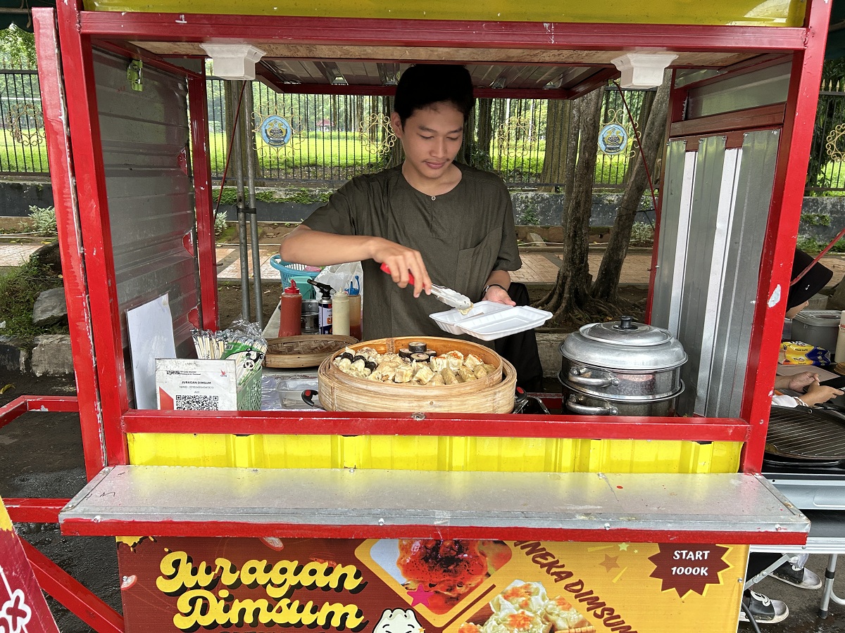VARIATIF: Alif tengah mempersiapkan menu pesanan pelanggan Juragan Dimsum di stan 24 Bazar Takjil Ramdan, Selasa (3/3).