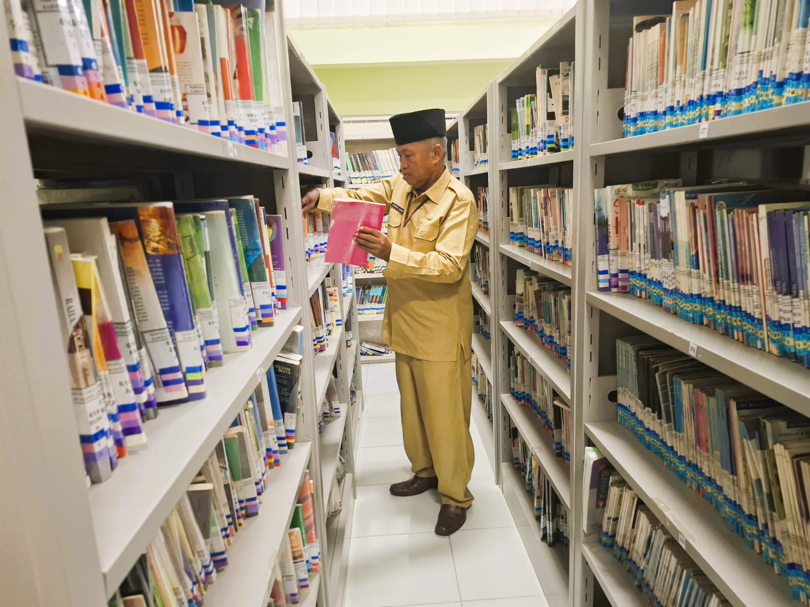 FOKUS: Seorang petugas tengah memperbaiki susunan buku di Perpustakaan Daerah Sumenep.