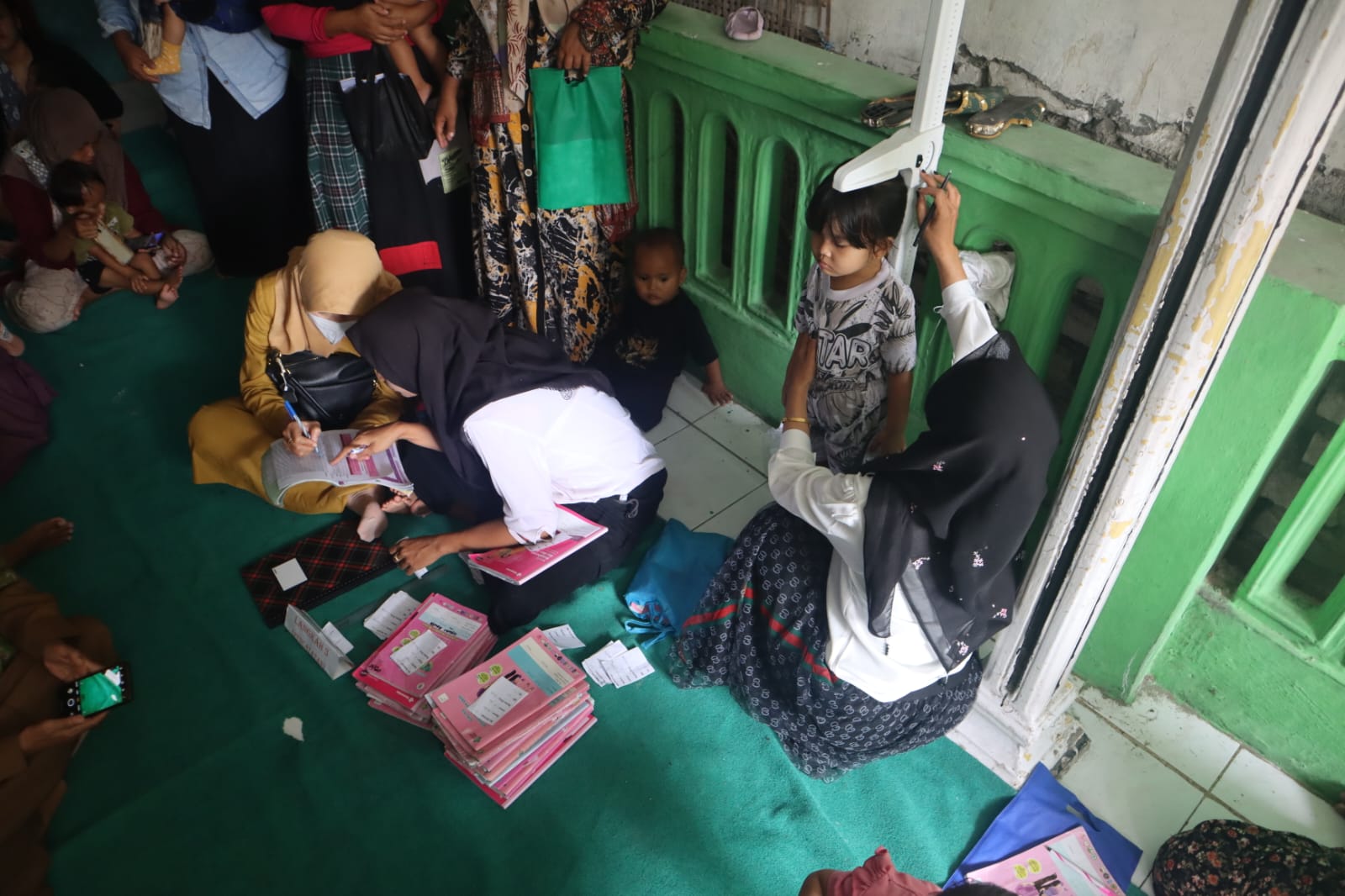 BERIKAN PELAYANAN: Petugas posyandu saat melakukan pemeriksaan kepada salah satu anak beberapa waktu lalu.