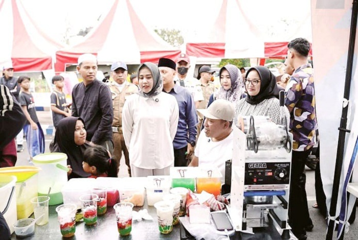 MERAKYAT: Bupati Sampang Slamet Junaidi menyapa warga saat memborong produk UMKM di bazar takjil di area Alun-Alun Trunojoyo Sampang, Minggu (8/3) sore. (PROTOKOL UNTUK JPRM)