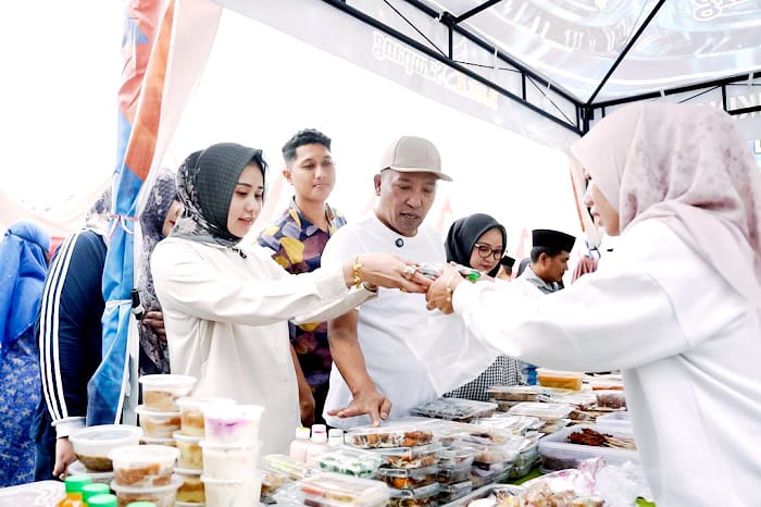 PEDULI: Bupati Sampang Slamet Junaidi dan istrinya saat membeli produk UMKM di bazar takjil di area Alun-Alun Trunojoyo Sampang, Minggu (8/3) sore. (PROTOKOL UNTUK JPRM)