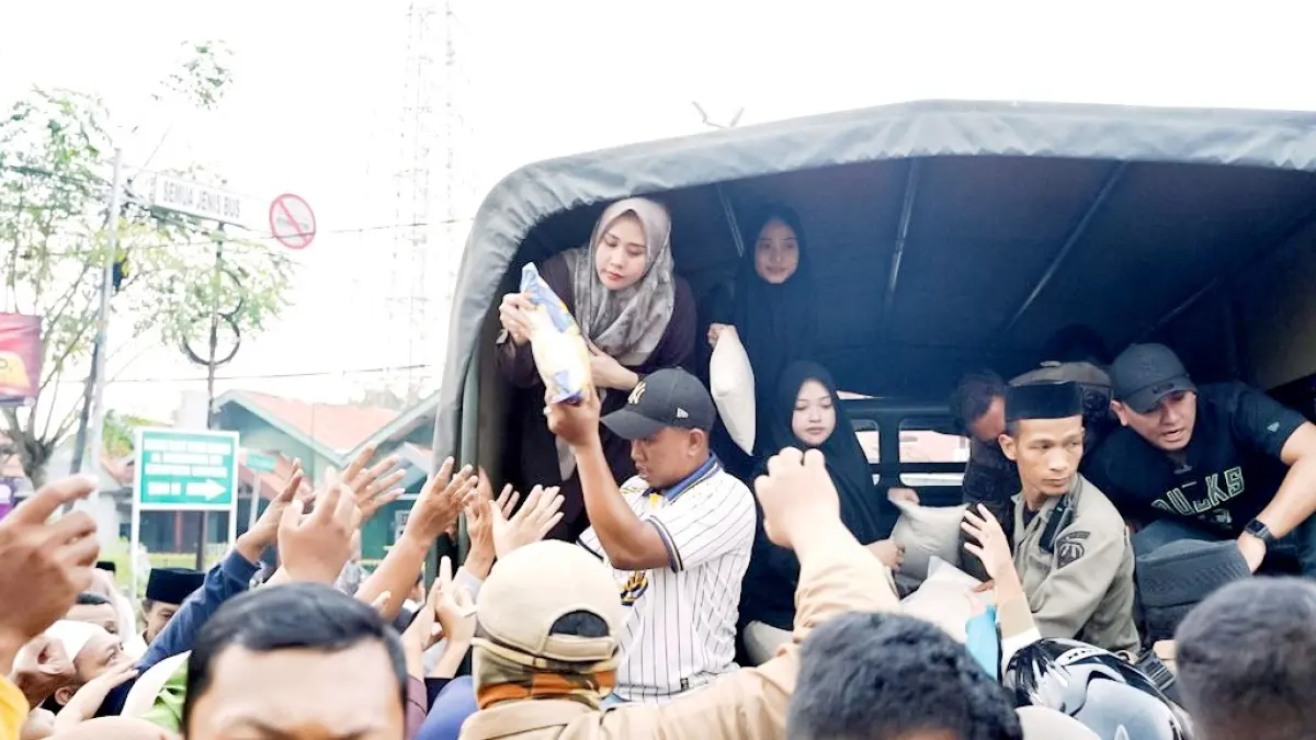 MERAKYAT: Ketua TP PKK Sampang Selviana Slamet Junaidi memberikan bantuan sembako pada masyarakat di Jalan Syamsul Arifin, Sampang, Minggu (15/3). (PROKOPIM UNTUK JPRM)