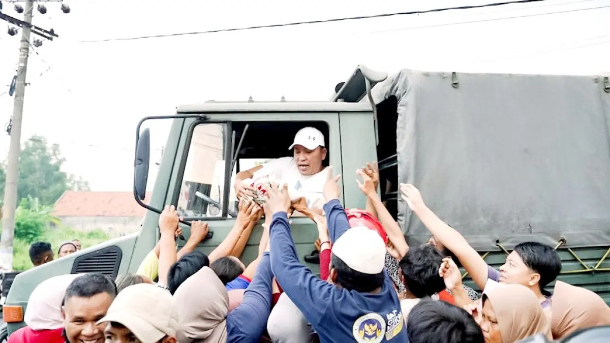 PEDULI: Bupati Sampang Slamet Junaidi membagikan sembako dari atas truk yang dikemudikannya, Minggu (15/3). (PROKOPIM UNTUK JPRM)