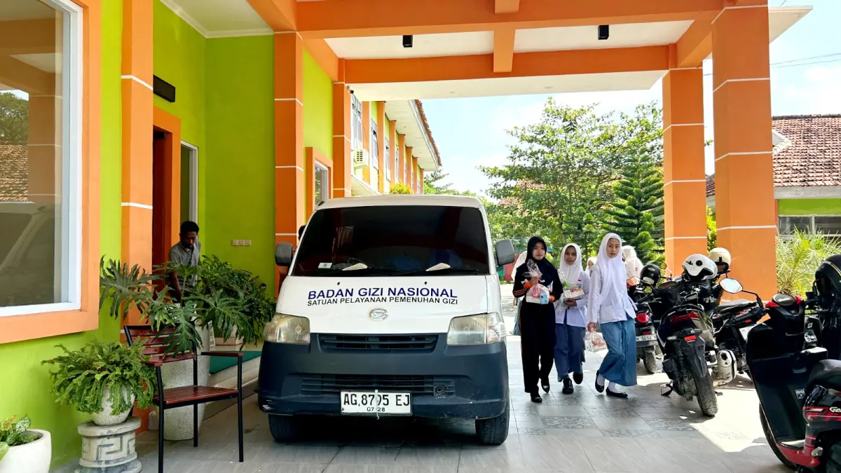 LALAI: Siswa SMKN 1 Sampang terlihat membawa MBG yang baru disalurkan Selasa (17/3). (UBAIDILLAHIR RAIE/JPRM)