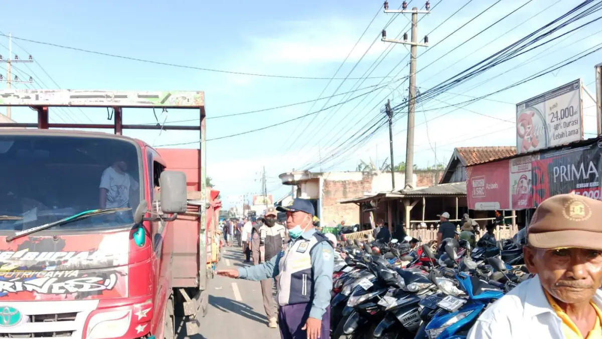 MACET TOTAL: Petugas Dishub Bangkalan mengawal arus lalin di Jalan Raya Patemon, Kecamatan Tanah, Rabu (18/3).