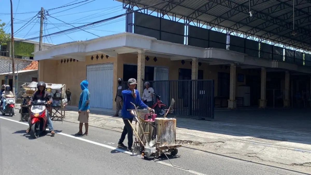 FASILITAS: Petugas memasang zebra cross di Jalan Imam Ghazali, Kamis (12/3). (AYU LATIFAH/JPRM)