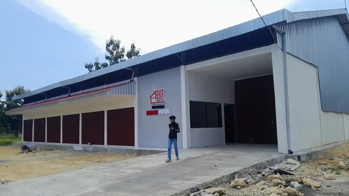 PROGRAM NASIONAL: Seorang pemuda berada di halaman gerai KDKMP di Kelurahan Kolpajung, Pamekasan, Senin (16/3). (M. KHOLIL RAMLI/JPRM)