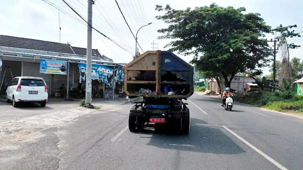 BUTUH PERBAIKAN: Truk sampah DLH Sumenep melintas di Jalan Jokotole, Kecamatan Batuan. (MOH. LATIF/JPRM)