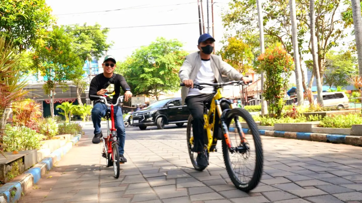 LAKSANAKAN TUGAS: Bupati Bangkalan Lukman Hakim (depan) mengayuh sepeda saat ke kantor pemkab, Kamis (26/3). (PROKOPIM UNTUK JPRM)