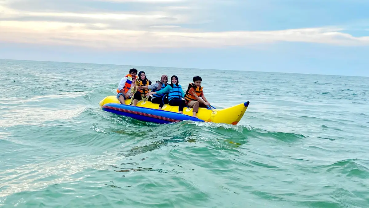 SERU: Wisatawan saat menaiki wahana banana boat di Pantai Lon Malang, Sampang, Minggu (22/3). (MASTUKI UNTUK JPRM)