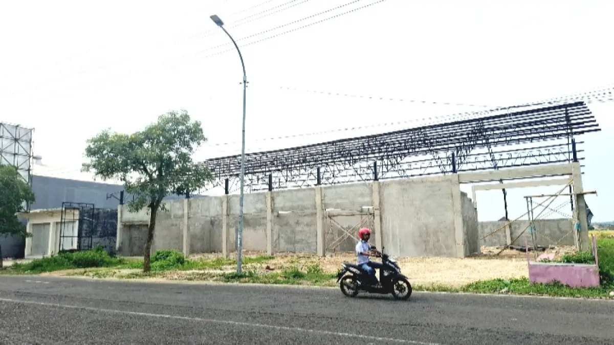 BELUM TUNTAS: Pengendara sepeda motor melintas di depan gerai KDMP di Jalan Jokotole, Desa Gedungan, Kecamatan Batuan, Sumenep, Kamis (26/3). (MOH. LATIF/JPRM)