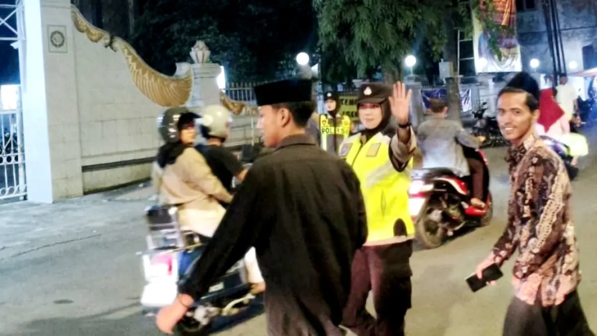 BERTUGAS: Aipda Asbiyah tengah bertugas mengawal lalu lintas di depan Masjid Agung Bangkalan. (ASBIYAH UNTUK JPRM)