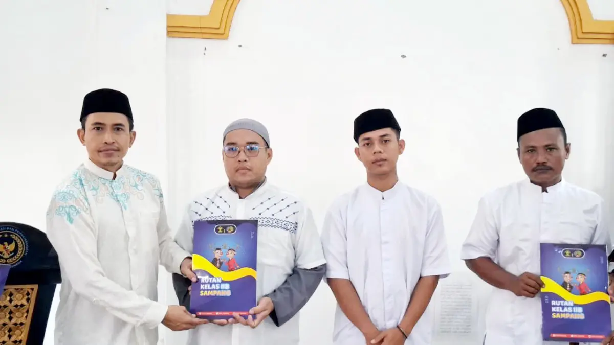 SIMBOLIS: Kepala Rutan Kelas II-B Sampang Kamesworo memberikan remisi kepada napi usai salat Idul Fitri di Masjid Rutan Kelas II-B Sampang, Sabtu (21/3). (RUTAN KELAS II-B SAMPANG UNTUK JPRM)