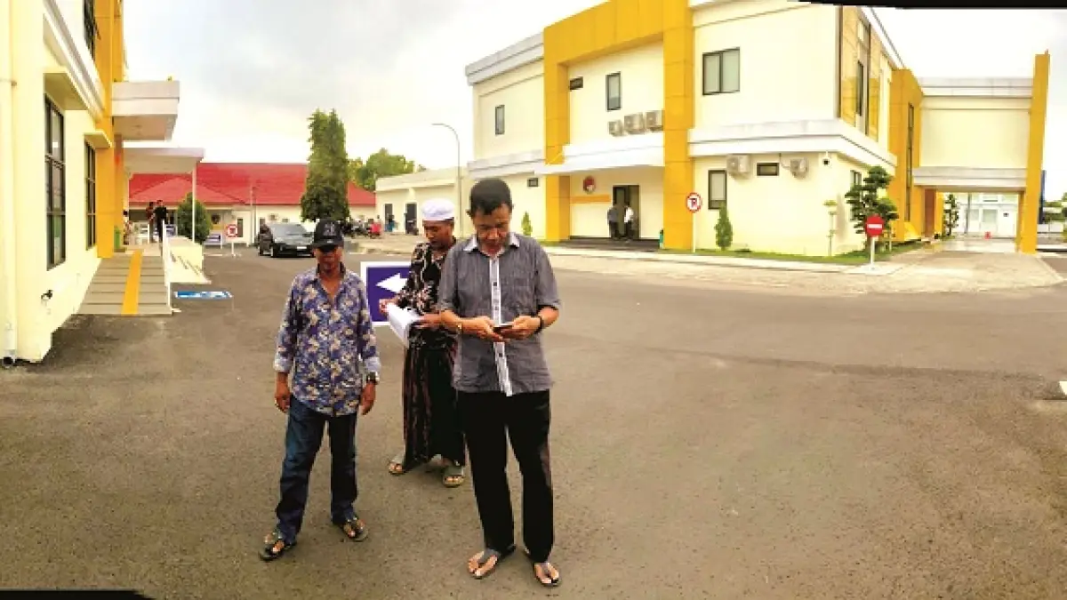 CARI KEPASTIAN: Dua pelapor berjalan ke area parkir seusai menjalani pemeriksaan di Satreskrim Polres Pamekasan, 26 November 2025. (DOK JPRM)