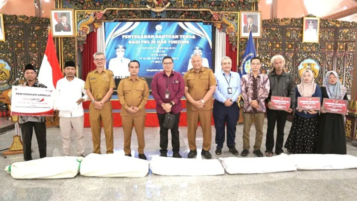 KOLABORASI: Bupati Bangkalan Lukman Hakim (empat dari kiri) menyerahkan foto setelah penyerahan tenda kepada PKL di Pendopo Agung Senin (30/3). (PROKOPIM UNTUK JPRM)