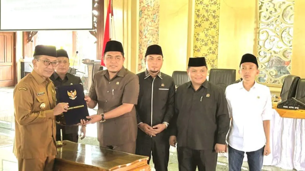 BERSAHAJA: Bupati KH. Kholilurrahman menyerahkan LKPj Tahun Anggaran 2025 kepada Ketua DPRD Pamekasan Ali Masykur dalam sidang paripurna di Pendopo Ronggosukowati Selasa (31/3). (MOH. ULIL AMRI UNTUK JPRM)