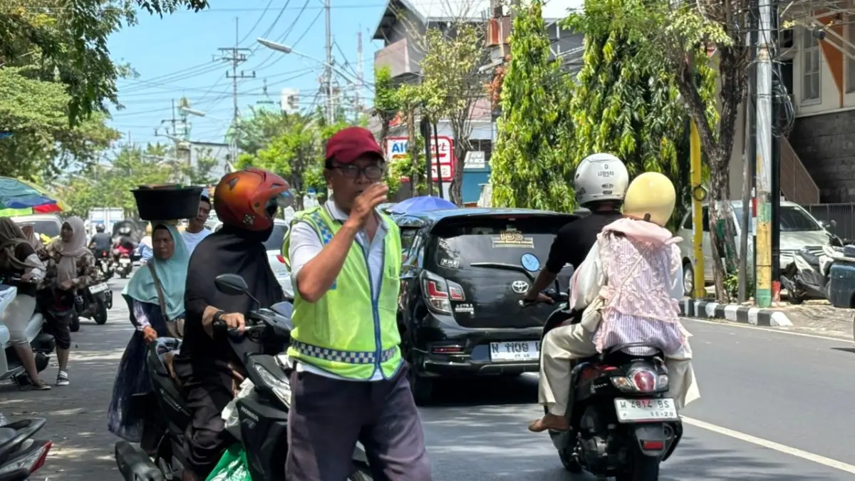 SUMBER PAD: Petugas juru parkir sedang mengatur kendaraan di Jalan Diponegoro, Kecamatan Pamekasan, Kamis (2/4).
