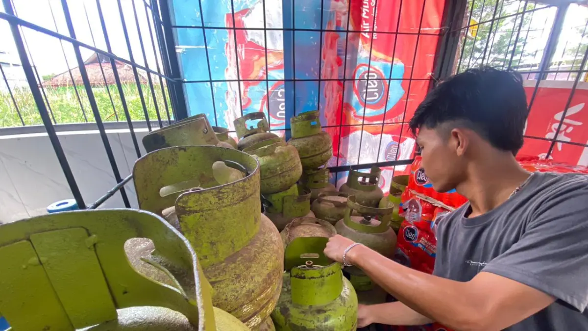 KEBUTUHAN: Royyan saat menyusun tabung LPG melon di tempatnya bekerja di Jalan Jamaluddin, Minggu (5/4).