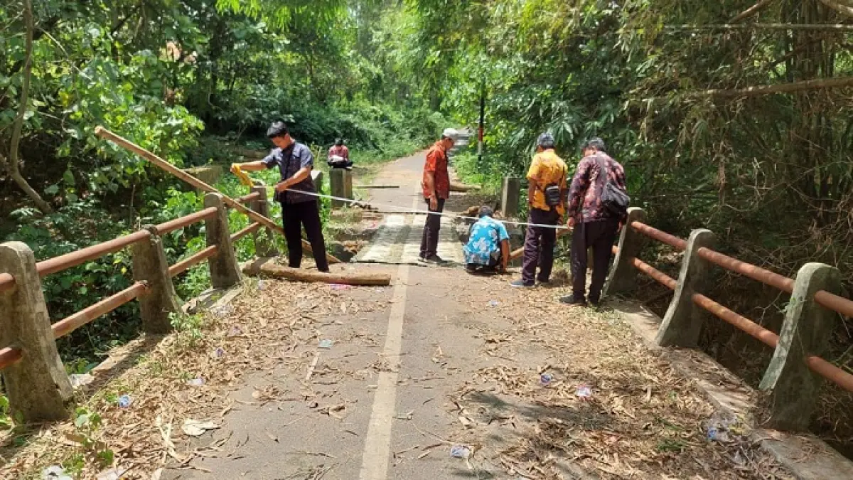 AMBRUK: Pegawai Dinas PUPR Pamekasan melakukan inspeksi khusus jembatan di Desa Pangorayan, Kecamatan Proppo, Senin (2/3). (DPUPR UNTUK JPRM)