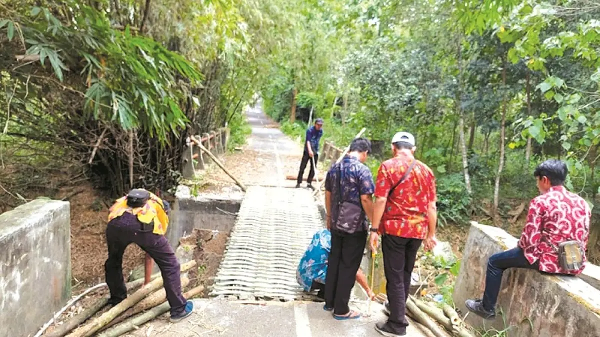 SIDAK: Pegawai Dinas PUPR Pamekasan berada di lokasi jembatan ambruk di Desa Pangorayan, Kecamatan Proppo, Senin (2/3). (DPUPR UNTUK JPRM)