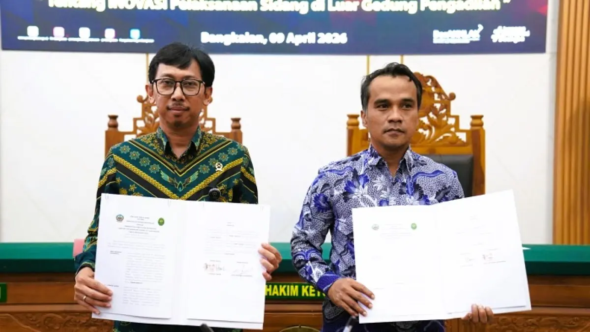 BERMITRA: Bupati Lukman Hakim (kanan) menunjukkan dokumen MoU dengan Ketua Pengadilan Negeri Bangkalan Arie Andhika Adikresna Kamis (9/4). (PROKOPIM UNTUK JPRM)