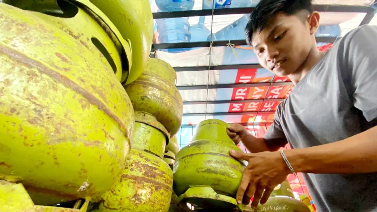 BARANG SUBSIDI: Seorang pemuda melihat stok LPG di Jalan Jamaluddin, Sampang, Minggu (5/4). (AYU LATIFAH/JPRM)