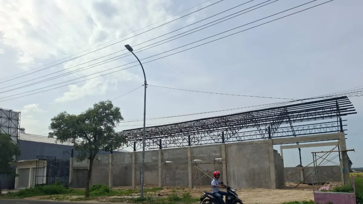 BELUM TUNTAS: Masyarakat melintas di depan gerai KDMP di Jalan Jokotole, Desa Gedungan, Kecamatan Batuan, Sumenep.&nbsp;