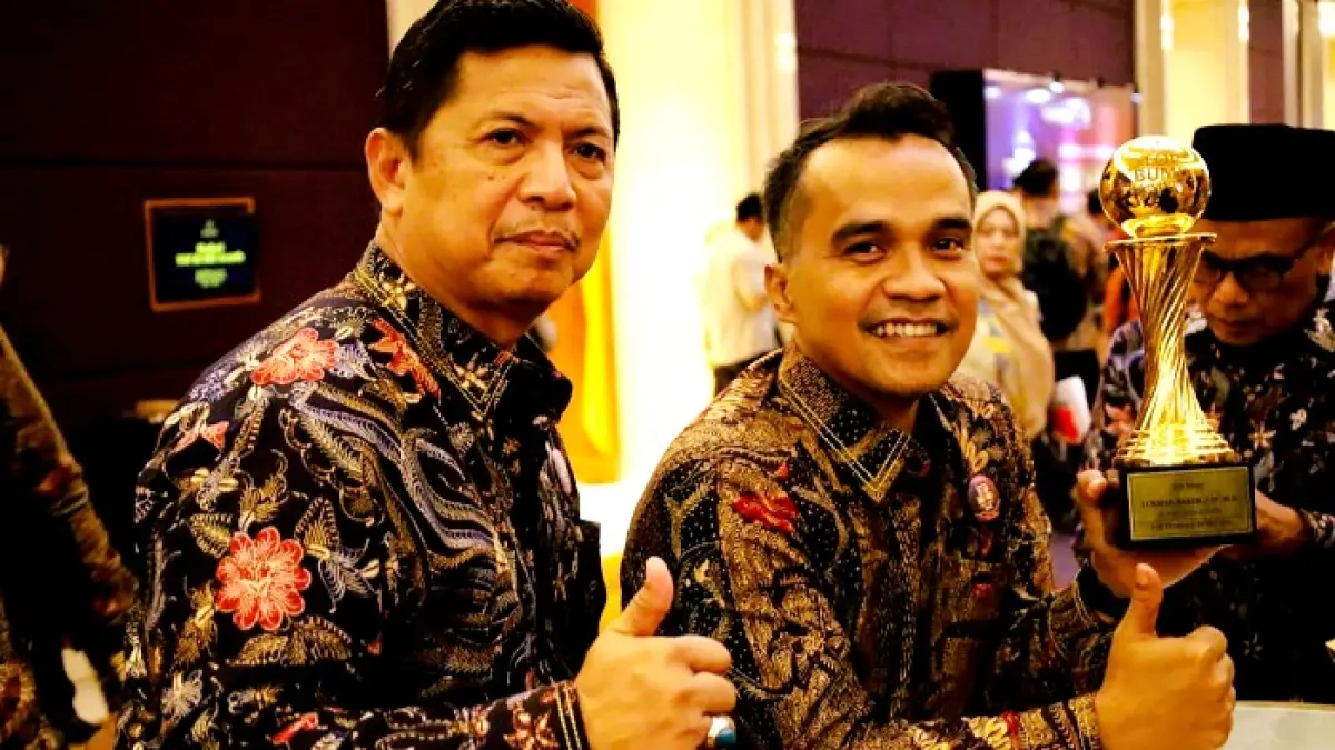 CAPAIAN POSITIF: Bupati Bangkalan Lukman Hakim (kanan) memperlihatkan trofi penghargaan Top Pembina BUMD 2026 dengan didampingi Kadiskominfo Zainal Alim. (PROKOPIM UNTUK JPRM)