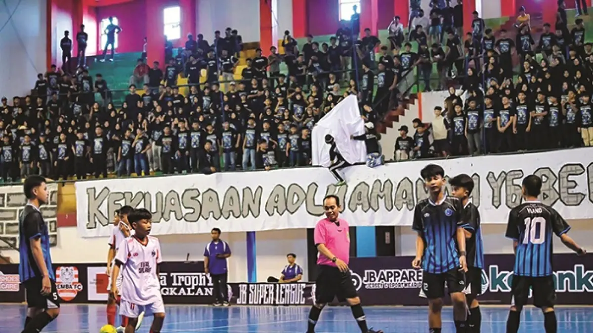 JUNJUNG SPORTIVITAS: Tim Futsal SMPN 1 Bangkalan (jersei putih) melawan SMPN 2 Bangkalan (jersei biru hitam) di GOR Sultas Abdul Kadirun Bangkalan Minggu (12/4). (ALRI INDRA LAKSANA UNTUK JPRM)