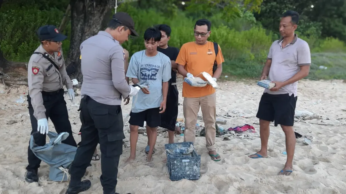 BARANG TERLARANG: Masyarakat bersama petugas saat mengecek temuan diduga kokain di pesisir Pantai Pasir Putih Kahuripan, Dusun Lombi Timur, Desa Gedugan, Kecamatan Gili Genting, Sumenep, Senin (13/4).