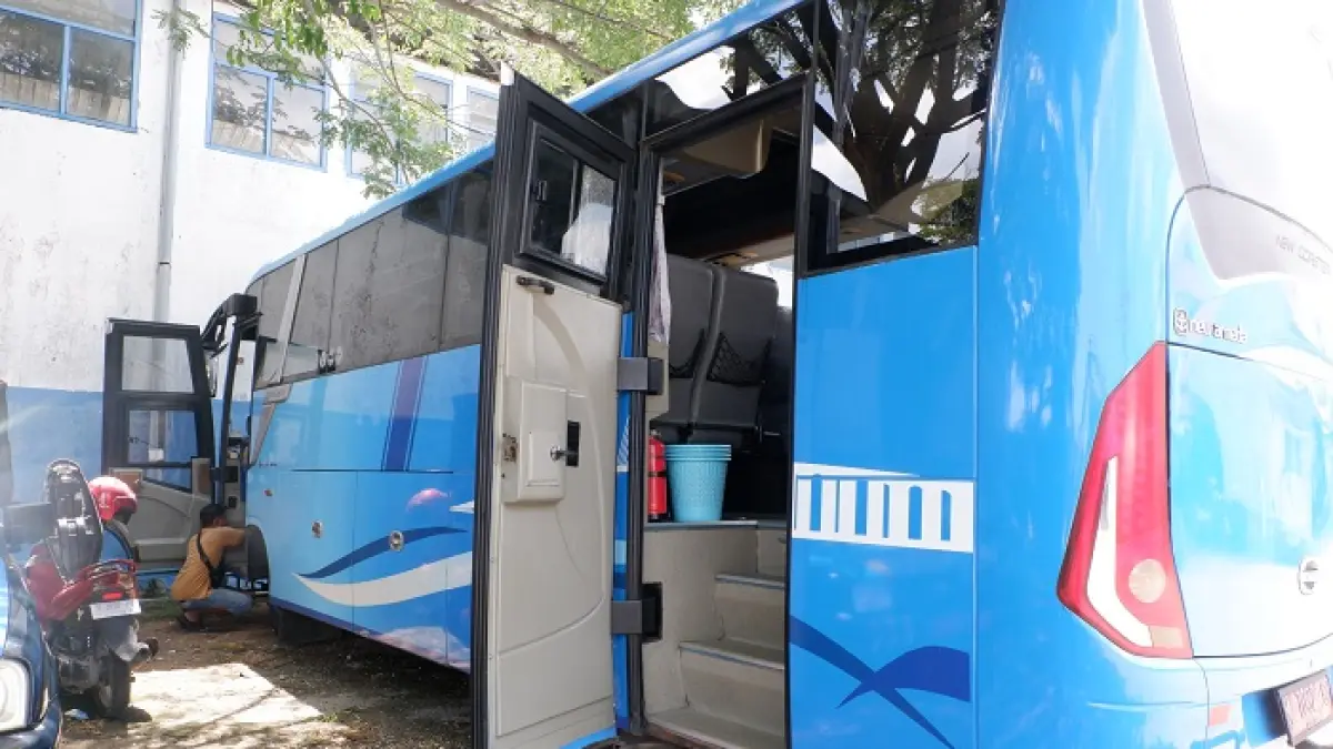 DIKANDANGKAN: Pekerja tampak mengecek armada bus milik Dinas Perhubungan (Dishub) Bangkalan Rabu (15/4). (VIVIN AGUSTIN HARTONO/JPRM)