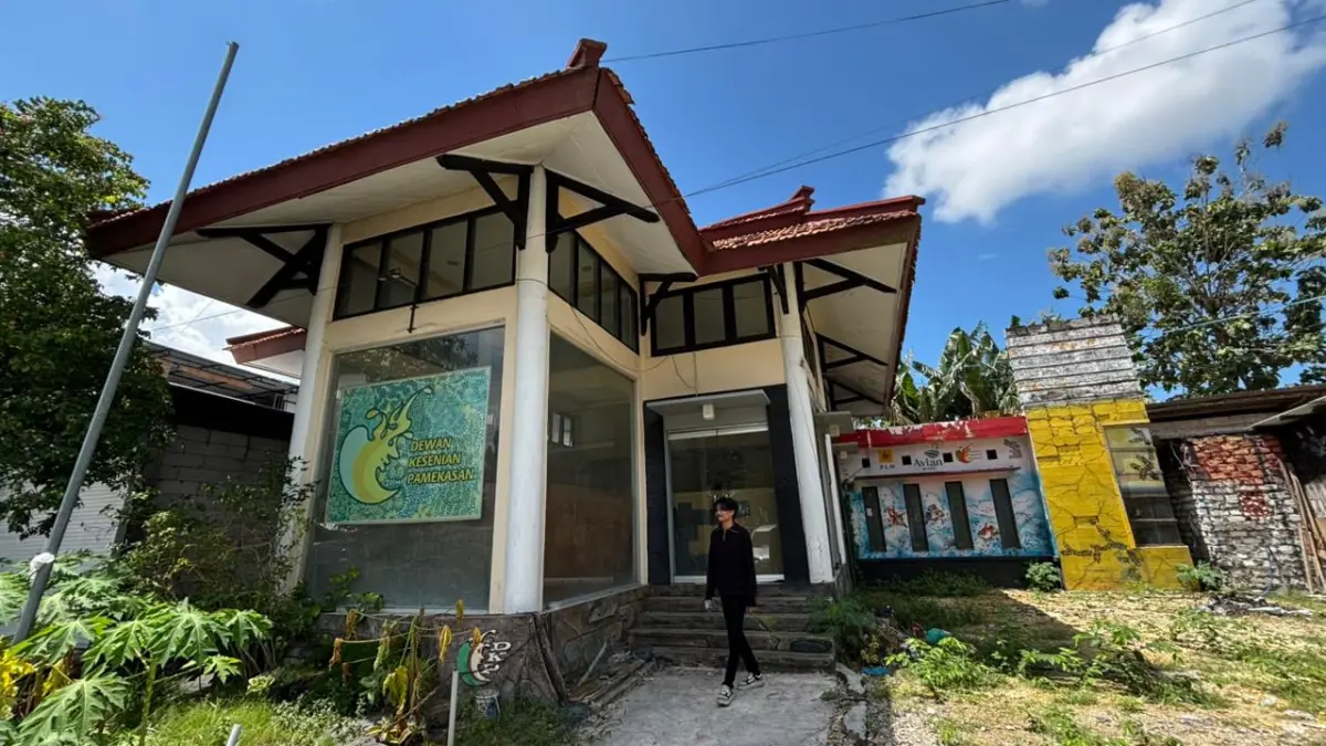 TERBENGKALAI: Seorang warga sedang berada di sekitar gedung kesenian Pamekasan di Jalan Trunojoyo, Selasa (14/4).