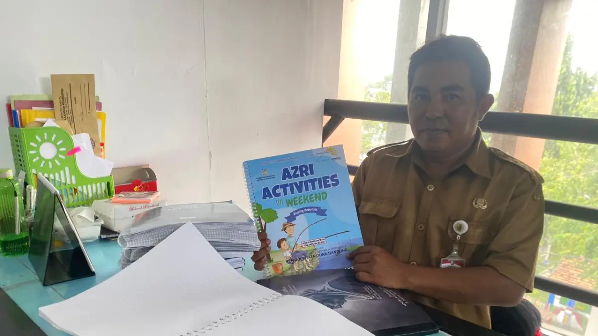 EDUKASI: Pustakawan saat menunjukkan buku Braille di gedung Perpusda Sampang selasa (14/4).