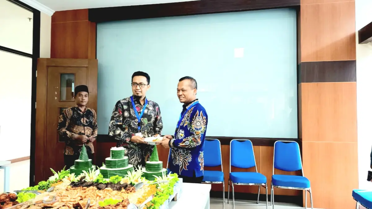 SIMBOLIS: Wakil Rektor I Bidang Akademik UTM Prof. Dr. Achmad Amzeri memberikan potongan tumpeng kepada Rektor UTM Prof. Dr. Safi