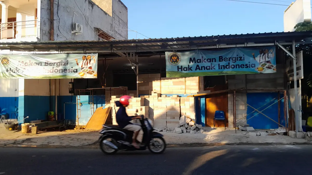 MELANGGAR: Warga sedang melintas di depan SPPG Kemala Bhayangkari yang sedang dalam proses perbaikan, Senin (20/4).