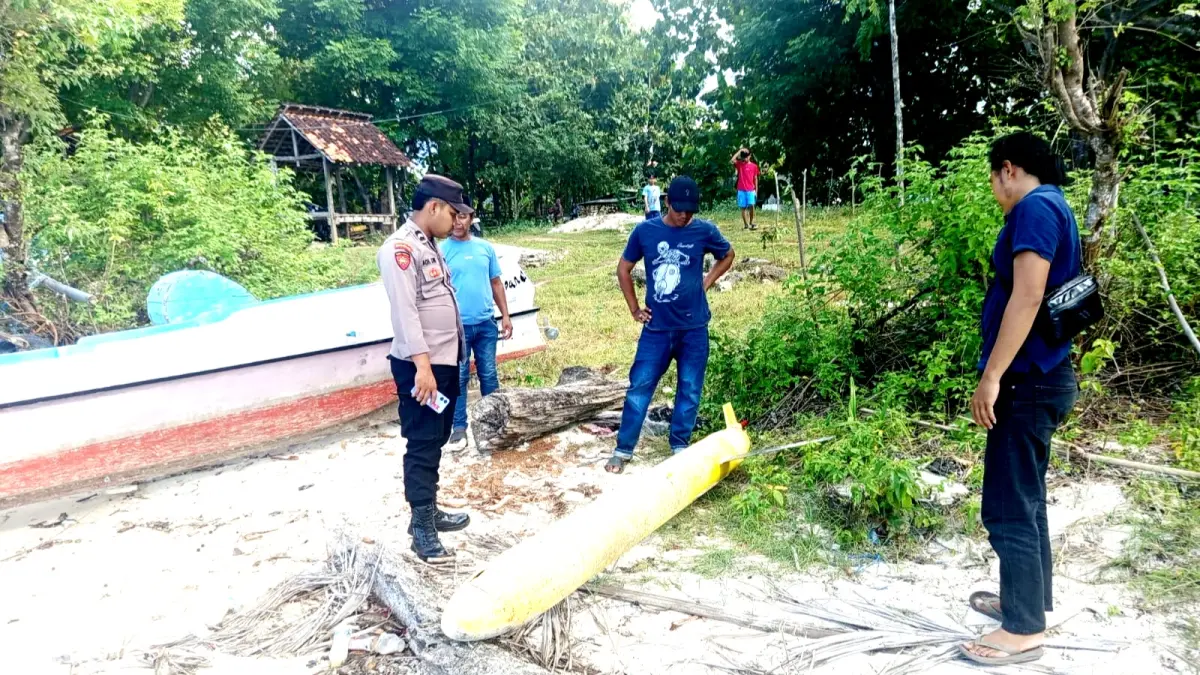 MISTERIUS: Petugas mendatangi lokasi penemuan benda mirip rudal di pesisir Desa Torjek, Kecamatan Kangayan, Sumenep, Senin (20/4). (POLRES SUMENEP UNTUK JPRM)