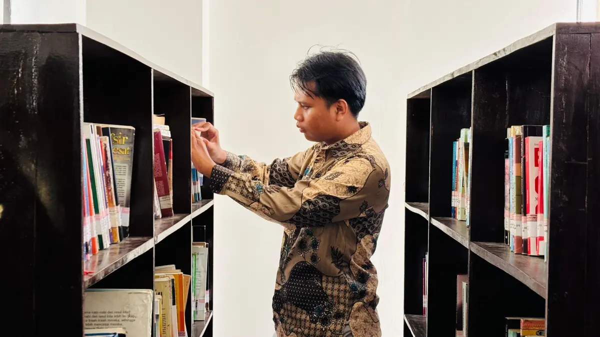 TAMBAH WAWASAN: Pemustaka sedang melihat koleksi buku di Perpustakaan M. Tabrani Pamekasan, Senin (20/4).