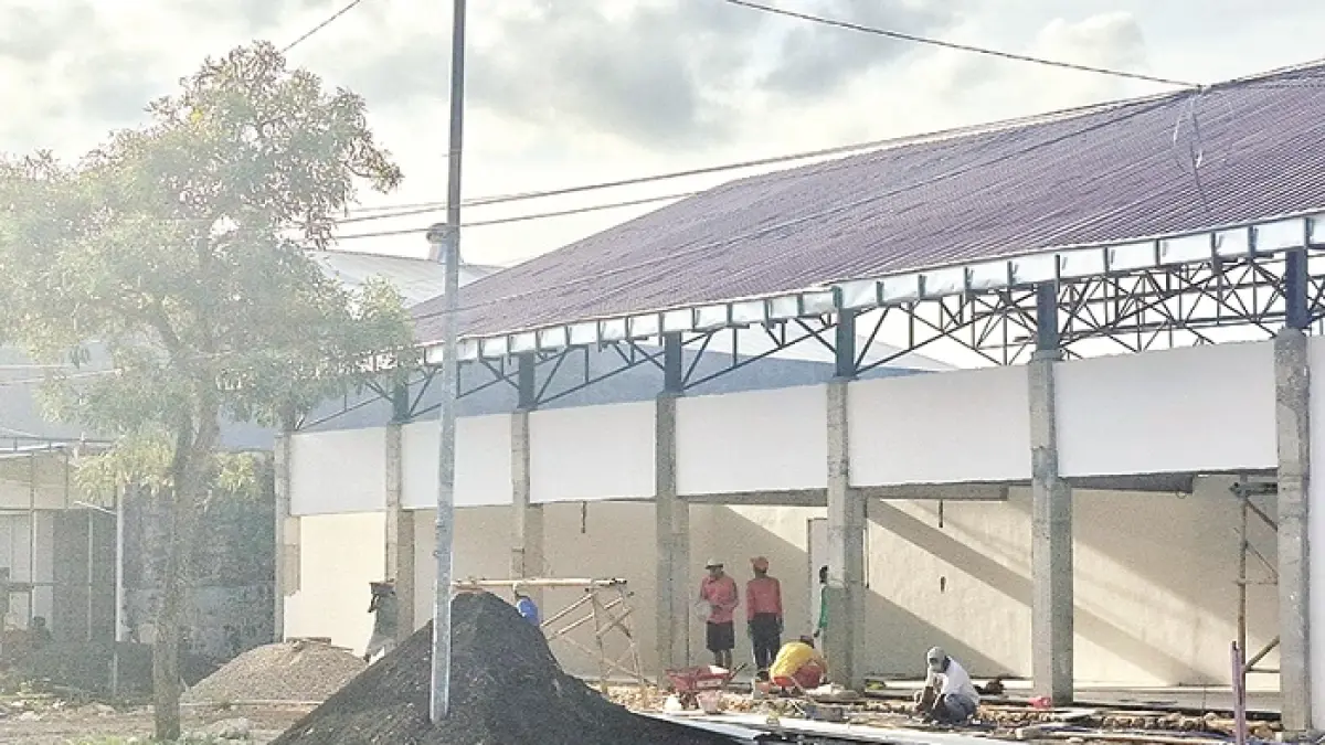 BELUM TUNTAS: Sejumlah pekerja tengah mengerjakan gerai KDMP di Jalan Jokotole, Desa Gedungan, Batuan, Sumenep, Jumat (24/4). (MOH. LATIF/JPRM)