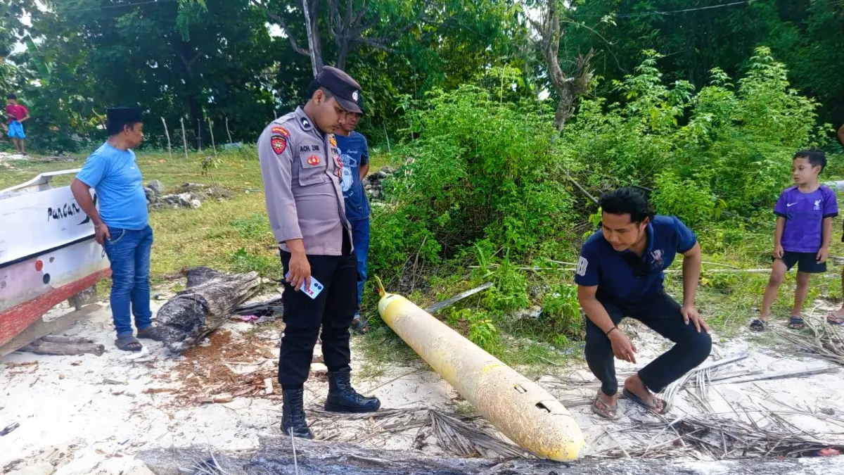 TERUNGKAP: Petugas memeriksa drone laut yang terdampar di pesisir pantai Desa Torjek, Kecamatan Kangayan, Sumenep, Selasa (21/4).