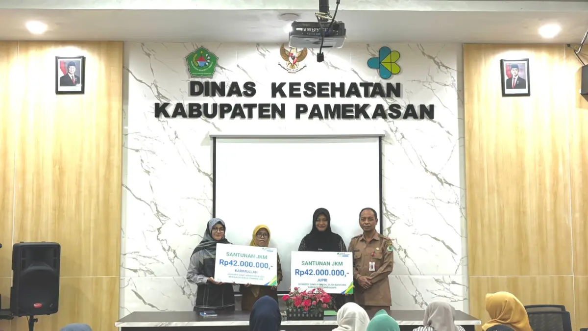 SERIUS: Kepala BPJS Ketenagakerjaan Pamekasan Anita Ardhiana (kiri) dan Kepala Dinkes Pamekasan Saifudin (kanan) berfoto bersama usai memberikan jaminan sosial ketenagakerjaan, Selasa (28/4). (MOH. IQBAL AFGANI/RM)