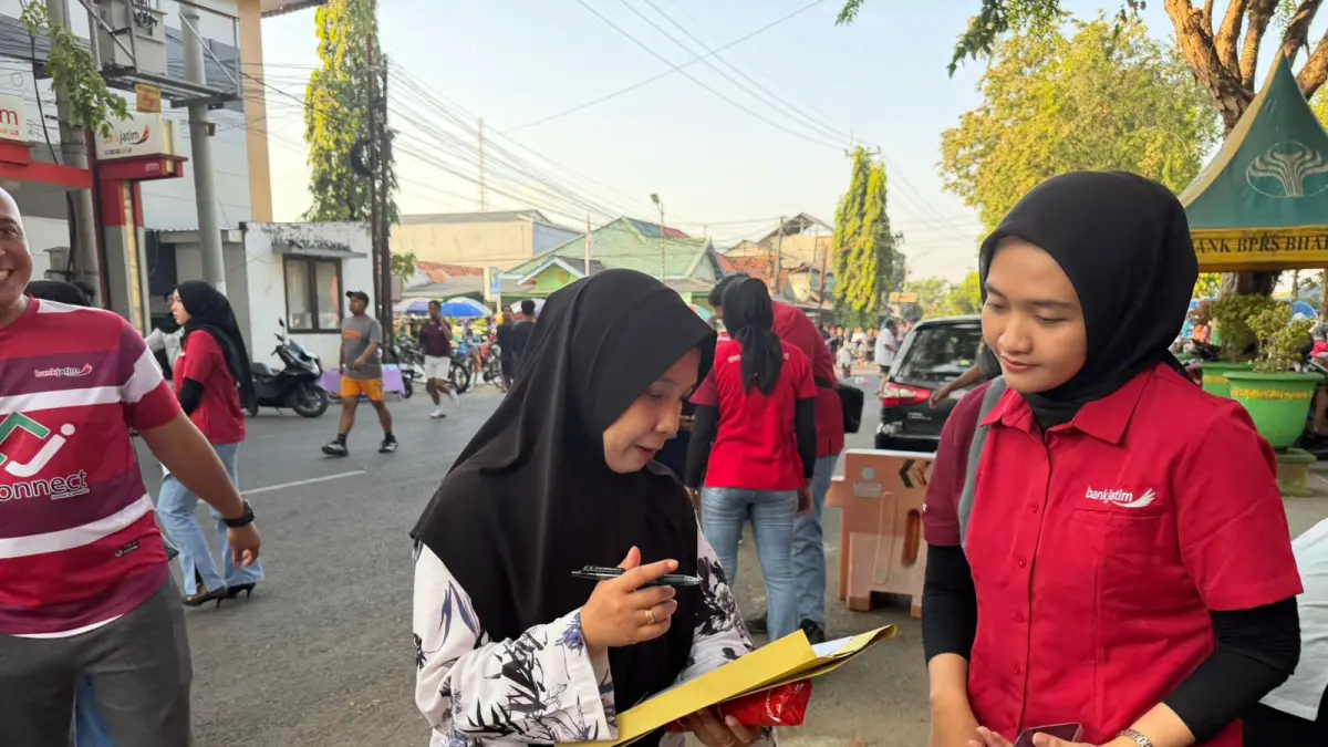 SOSIALISASI: Karyawan Bank Jatim Cabang Sumenep menjelaskan aplikasi JConnect Mobile versi terbaru kepada masyarakat saat car free day di Taman Bunga Sumenep, Minggu (19/4).