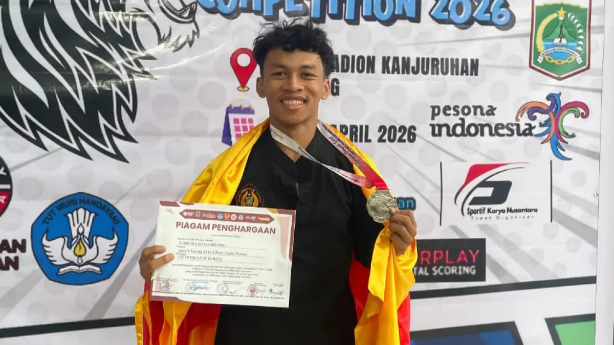 BERPRESTASI: Febri Sulistyo Arnowo, atlet PSHT Sampang, menunjukkan medali perak dan piagam penghargaan yang diperolehnya pada kejuaraan Pencak Silat Liga Pelajar Competition 2026 di GOR Kanjuruhan, Kabupaten Malang, Minggu (26/4).