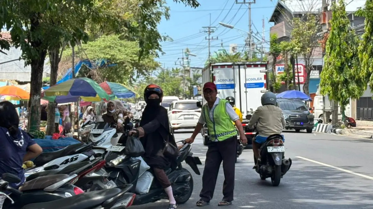 SUMBER PAD: Jukir mengatur kendaraan di Jalan Diponegoro, Kecamatan Pamekasan, Sabtu (2/5).