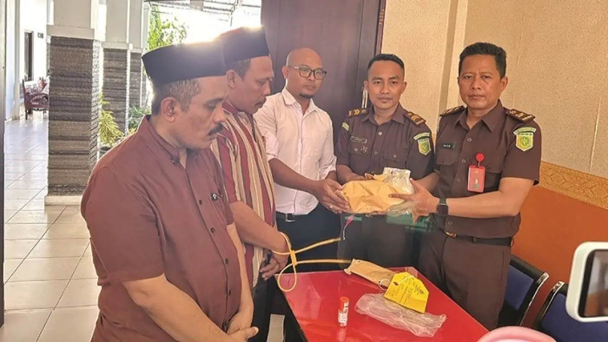 DILIMPAHKAN: Dua tersangka saat pelimpahan tahap dua di kantor Kejari Sampang Senin (4/5). (UBAIDILLAHIR RA’IE/JPRM)