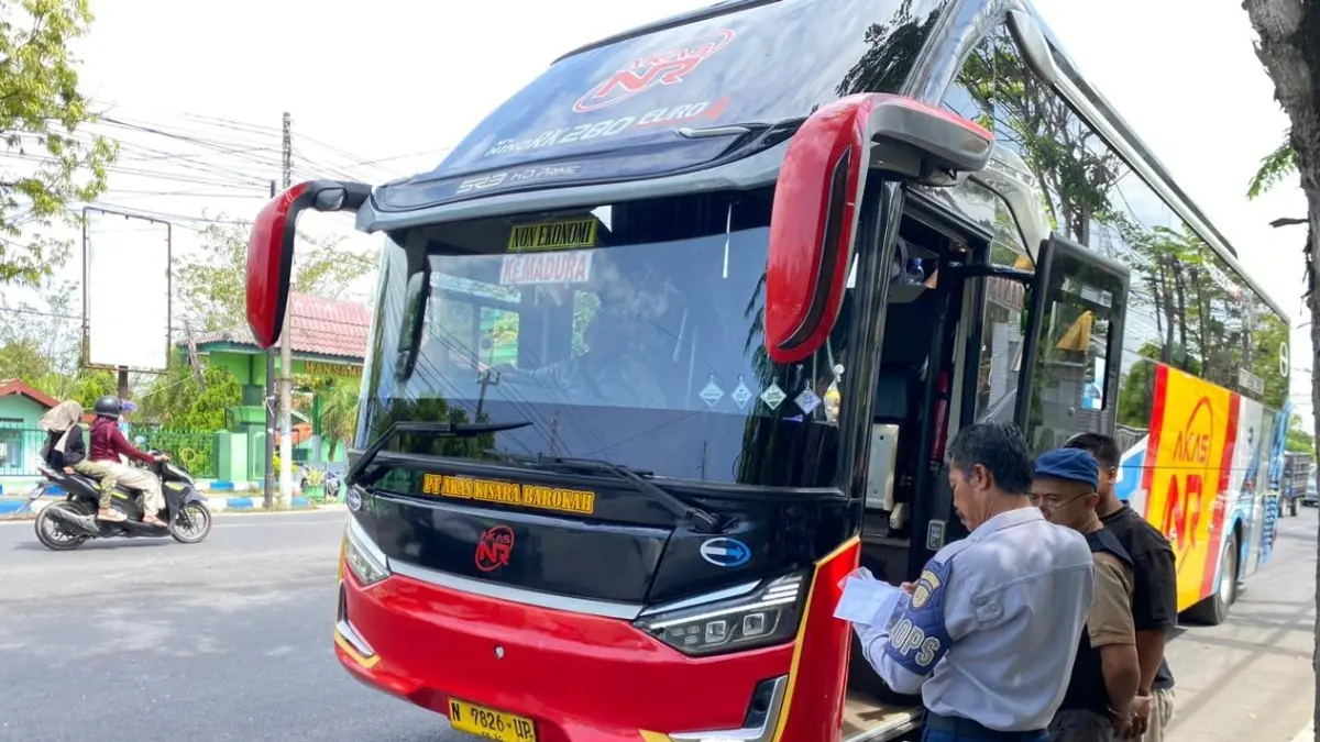 DIPERIKSA: Petugas dishub memeriksa dokumen uji track bus di Jalan Jaksa Agung Suprapto, Sampang, Senin (4/5).